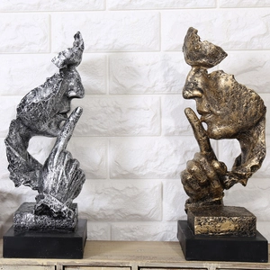 Détail de sculptures en résine argent et or illustrant le geste le silence est d'or