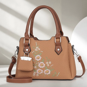 Brown woven handbag with floral embroidery, leather handles and detachable strap