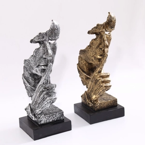 Vue détaillée des sculptures Le silence est d'or en résine or et argent sur socles