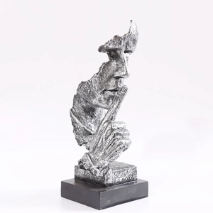 Gros plan détaillé de la sculpture argentée Le silence est d'or avec texture vieillie