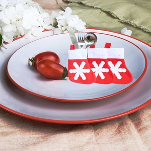 Detailed view of three mini red snowflake Christmas stockings used as festive cutlery holders