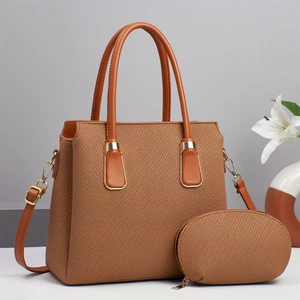 Detail of tan tote bag set with textured fabric, gold hardware and matching coin purse