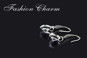 Macro shot of 8mm round brilliant-cut diamond drop earrings on reflective black background