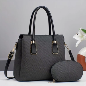 Detail view of dark grey textured tote bag set with golden hardware and matching pouch