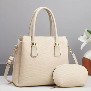Detail of elegant cream handbag set with gold hardware and a matching small zipper pouch