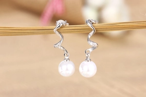 Detailed close-up of S925 silver spiral earrings with white pearls and micro-zirconia