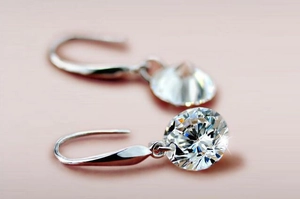 Macro shot of 8mm round brilliant-cut gemstone earrings with silver teardrop hooks