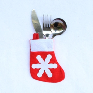 Close-up of red Christmas stocking cutlery holder with snowflake pattern on white background