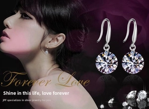 Detail view of 8mm round crystal drop earrings with silver hooks on an elegant model