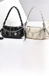 Detail view of stylish pleated hobo bags with metallic charms and woven handles
