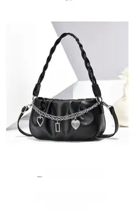 Detail of black pleated tote bag with silver chains and crystal heart charms