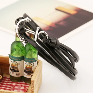 Close-up of a multilayer black leather nautical bracelet featuring a silver anchor charm