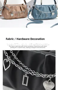 Detail of ruched handbag featuring dual silver chains with rhinestone heart pendants