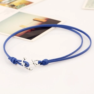 Detail of blue double-wrap leather bracelet featuring a silver anchor-shaped metal clasp