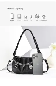 Detailed view of black pleated shoulder bag with silver chains and heart pendants showing capacity