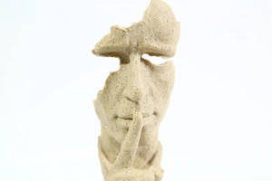 Gros plan sur la texture en grès beige d'une sculpture avec le geste du silence