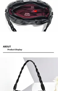 Detail of the black pleated handbag showing red lining and multi-compartment interior structure