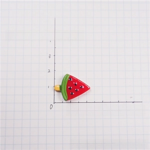 Detail view of 20mm watermelon popsicle resin charm with Mickey-shaped seeds on grid paper