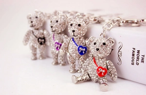 Detail view of sparkling rhinestone teddy bear keychains with colorful heart pendants