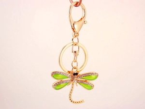 Detailed view of green enamel dragonfly keychain with crystals and gold plating