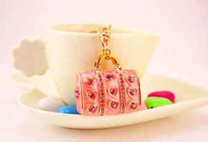 Detailed view of pink handbag keychain with heart-shaped rhinestones on gold metal