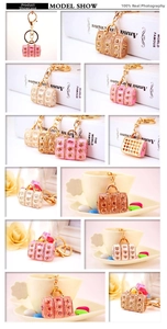 Detailed macro of crystal-encrusted handbag keychains in pink, cream, and brown finishes