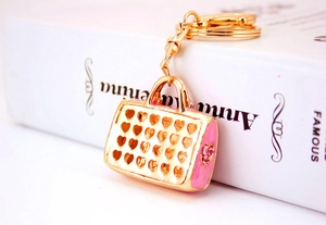 Close-up of pink handbag keychain with heart cutouts and sparkling pink crystals