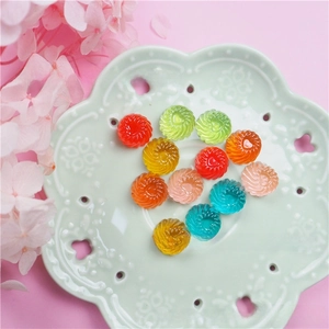 Colorful spiral resin candy charms for DIY crafts and hair accessories in a decorative dish