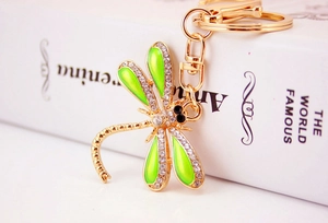 Detailed macro view of dragonfly keychain featuring green enamel wings and white rhinestones