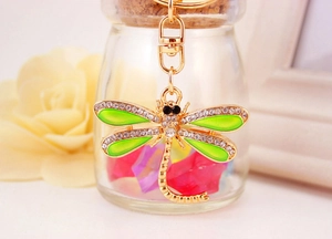 Close-up of green dragonfly keychain with sparkling crystals and gold metal finish