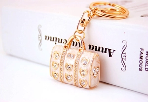 Macro shot of handbag pendant keychain with beige enamel and heart crystals on book