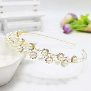 Close-up of double-layered gold headband with delicate pearls and sparkling rhinestones