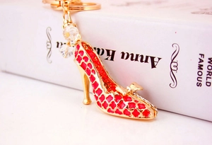 Détail du porte-clés escarpin doré avec motifs en émail rouge et strass brillants