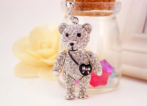 Macro detail of silver rhinestone teddy bear keychain with heart bag and metal ring