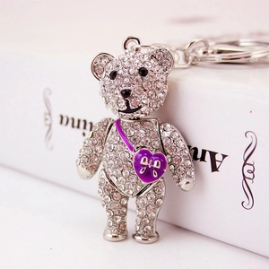 Sparkling teddy bear keychain with white rhinestones and a purple heart bag detail