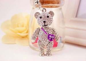 Close-up of sparkling teddy bear keychain with crystal rhinestones and purple heart bag