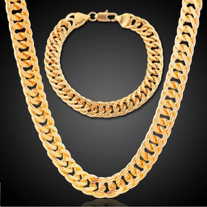 Polished gold Cuban link necklace and bracelet set displayed on a dark background