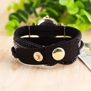 Detail of a wrap bracelet watch with black suede strap and sparkling crystals for women
