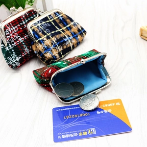 Christmas tartan coin purse with metal clasp featuring snowflakes on a wooden background