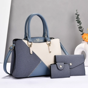 Detailed shot of three-piece tote set with elegant bow print and gold hardware detail