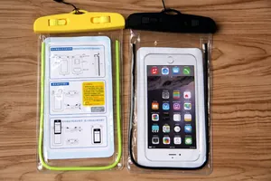 Close-up of IPX8 waterproof phone pouches with ABS lock clips on wood background