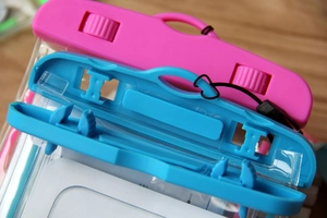 Close-up of dual rotary locks on waterproof phone pouches in pink and blue colors