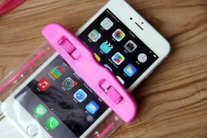 Close-up of pink waterproof phone pouch with rotating secure lock on wooden background