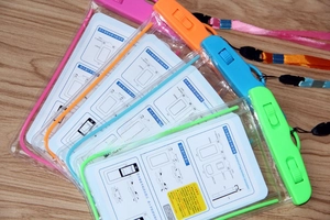 Detail of four colorful luminous waterproof phone pouches with secure mechanical seals