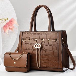 Macro detail of dark brown crocodile texture surface and golden hardware on handbag