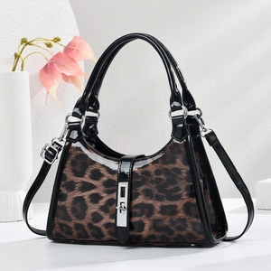 Chic leopard print crescent shoulder bag with glossy black patent leather and silver clasp