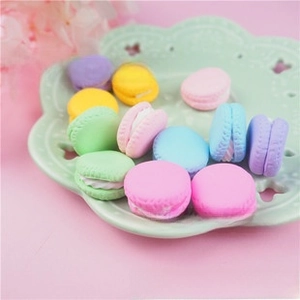 Vue macro de miniatures macarons en résine colorée avec garniture réaliste sur plat en céramique