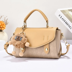 Sac à main beige en cuir matelassé avec pendentif lion et ferrures dorées