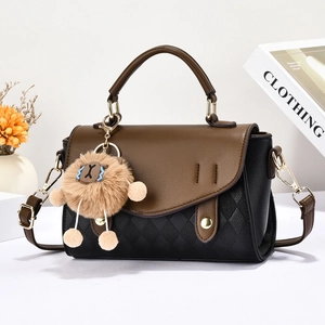 Détail du sac à bandoulière montrant le rabat marron et le motif matelassé avec un ours