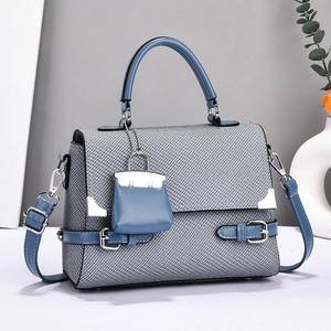 Chic grey-blue woven crossbody bag with circular handle and mini pouch charm